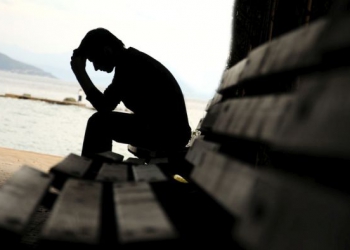 Young man sitting looking upset