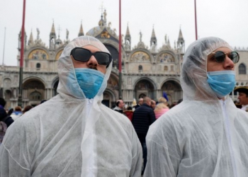 Tourists wear protective face masks at Venice Carnival, which the last two days of, as well as Sunday night's festivities, have been cancelled because of an outbreak of coronavirus, in Venice, Italy February 23, 2020. REUTERS/Manuel Silvestri