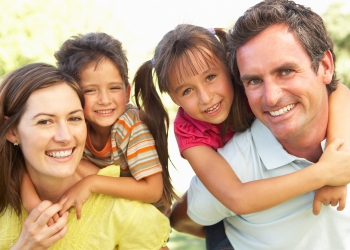 Mother And Father Giving Children Piggy Back