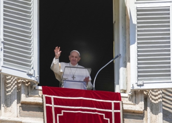 Pope Francis waves during the Angelus noon prayer from the window of his studio overlooking St.Peter's Square, at the Vatican, Sunday, March 13, 2022. (AP Photo/Gregorio Borgia)