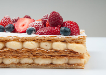 Puff pastry cake with custard cream. Close-up of sweet summer dessert with berries. Food concept