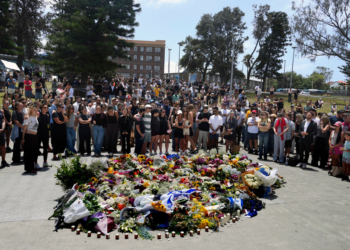 A growing number of people gather around a flower memorial at the Bondi Pavilion at Sydney's Bondi Beach, Monday, Dec. 15, 2025, a day after a shooting. (AP Photo/Mark Baker)