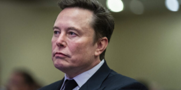 Elon Musk listens as President-elect Donald Trump speaks during a meeting with the House GOP conference, Wednesday, Nov. 13, 2024, in Washington. (Allison Robbert/Pool via AP)